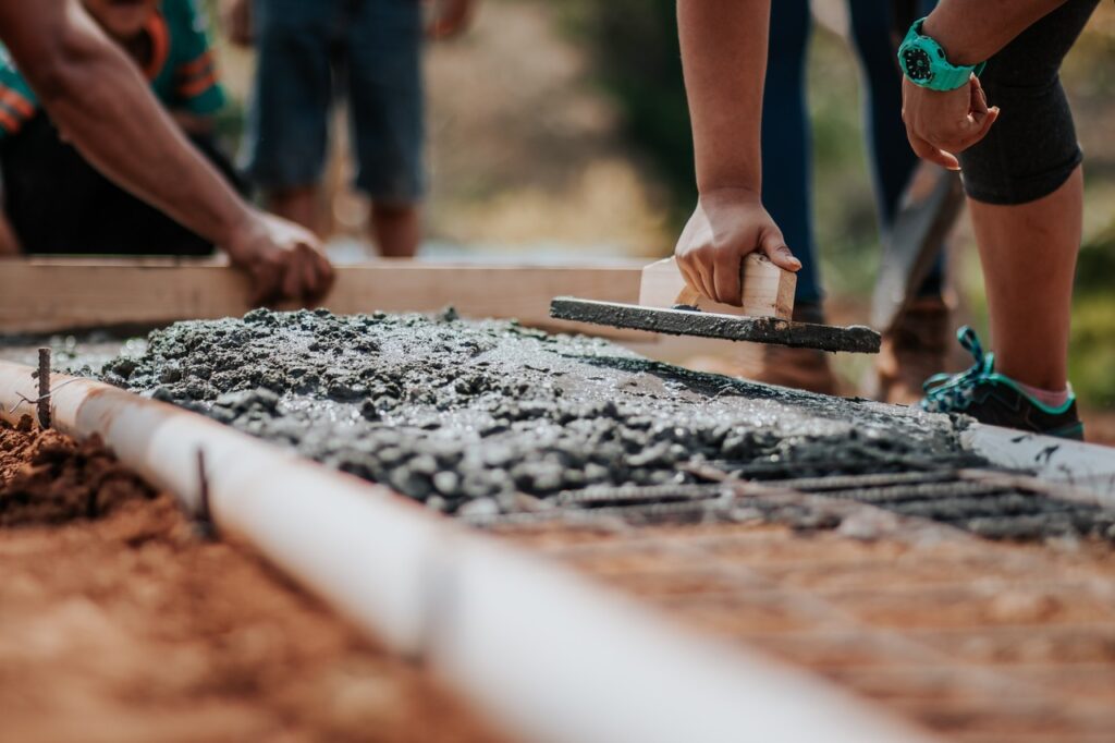 Pessoas realizando a concretagem na obra